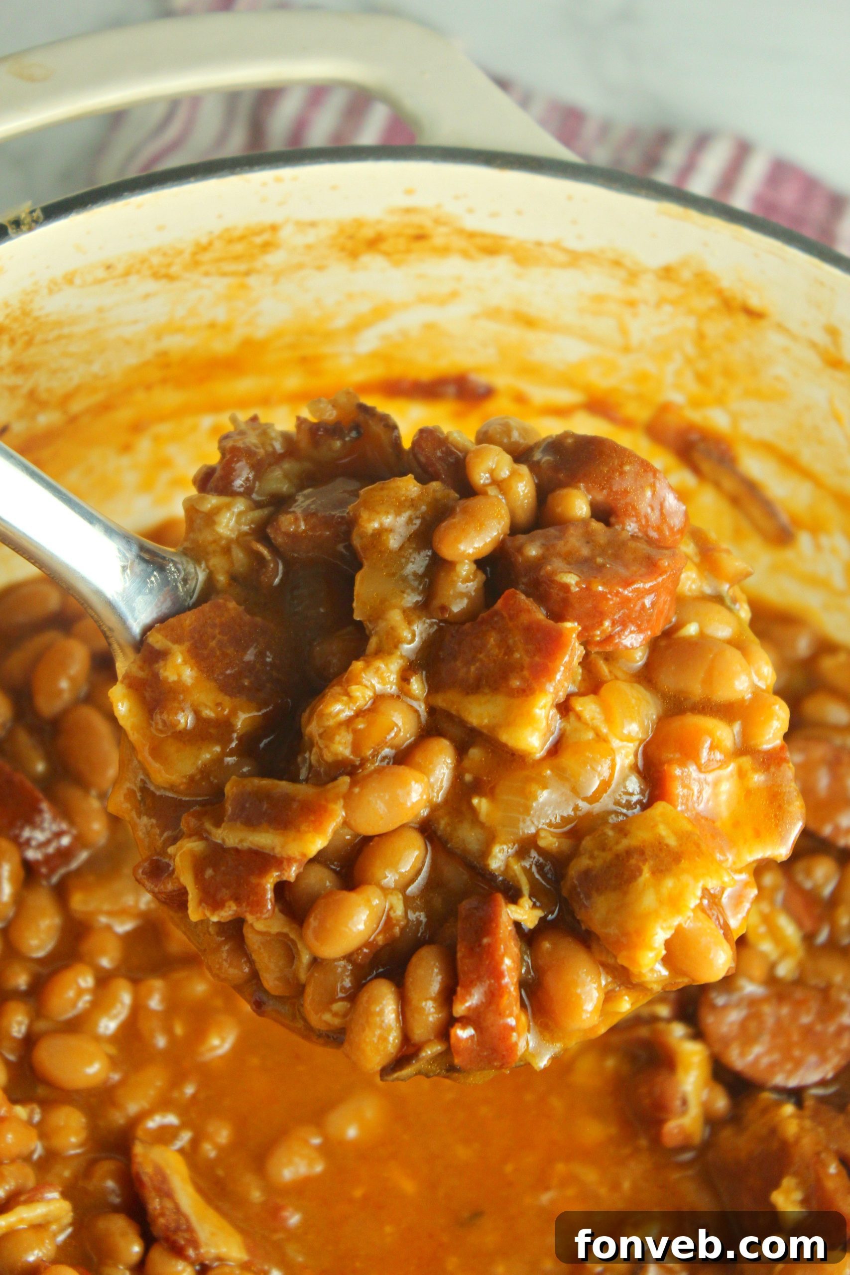Signature Smoked Sausage Baked Beans 12 Ultimate Baked Beans with Smoked Sausage in a red Dutch oven pot, ready to be served