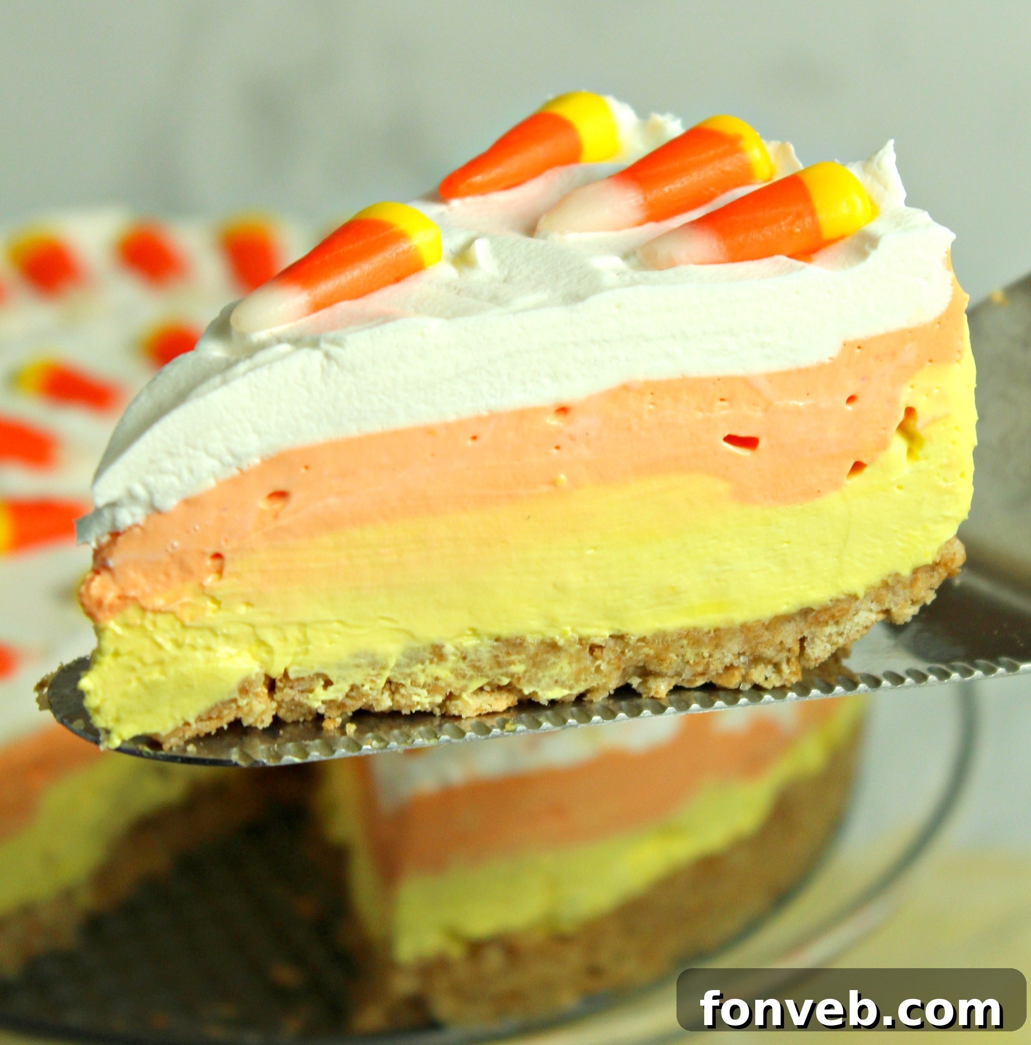 Effortless Autumn Candy Corn Cheesecake 5 A vibrant slice of No Bake Candy Corn Cheesecake, showcasing its layers.
