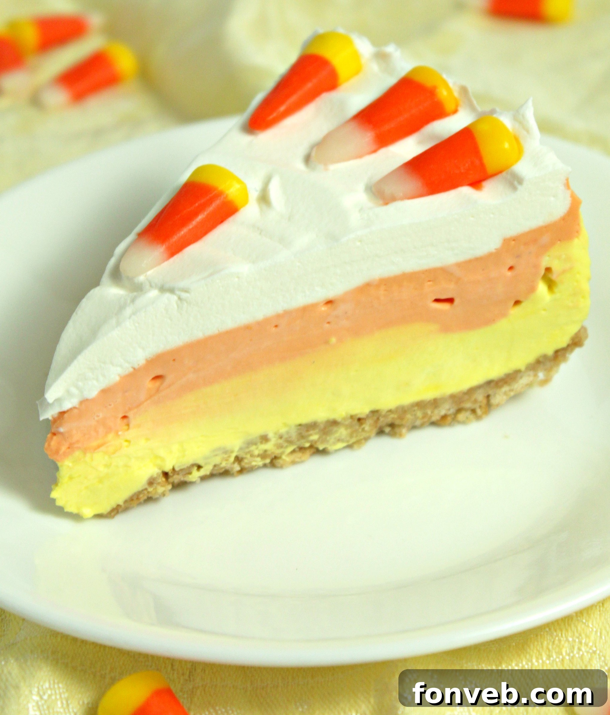 Effortless Autumn Candy Corn Cheesecake 6 A No Bake Candy Corn Cheesecake garnished with actual candy corn.