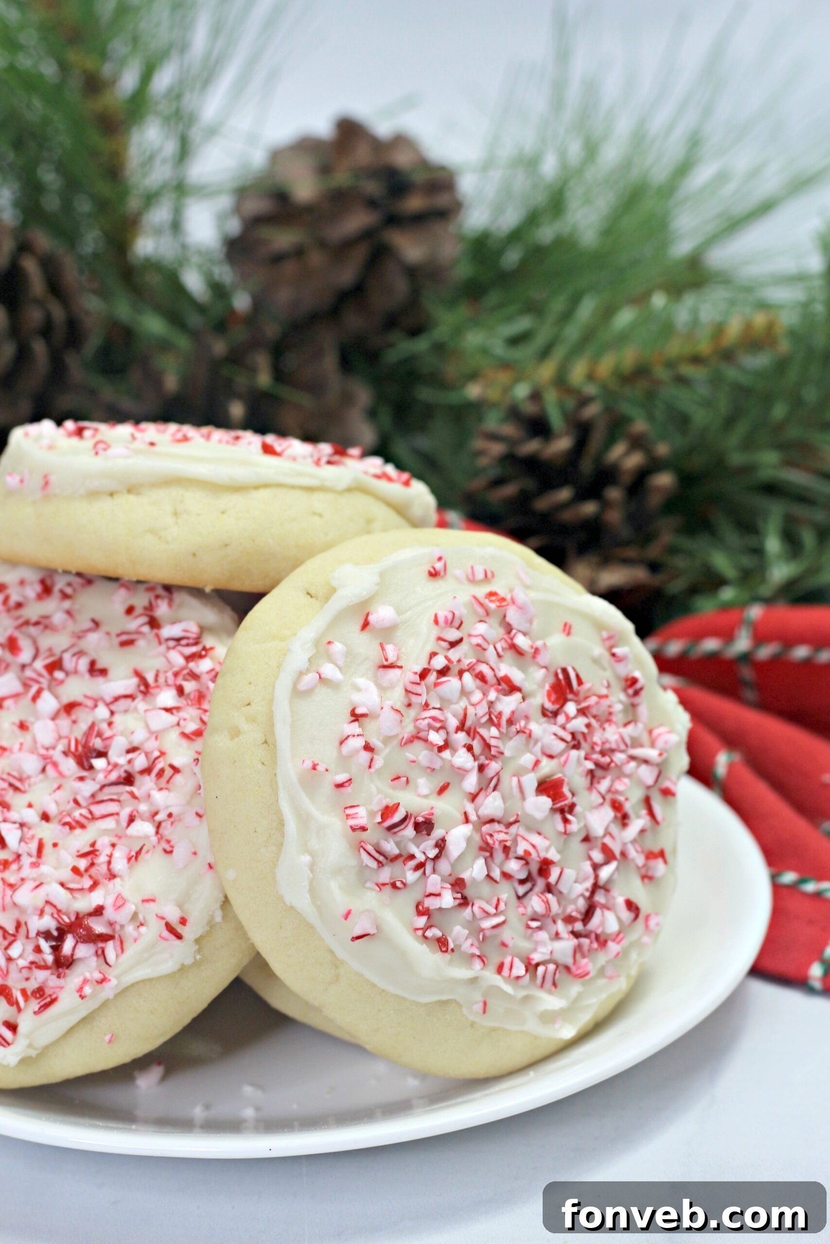 A close-up of a single Amish Sugar Cookie, beautifully iced and topped with crushed peppermint, resting on a cooling rack, emphasizing its professional finish and tempting appeal.