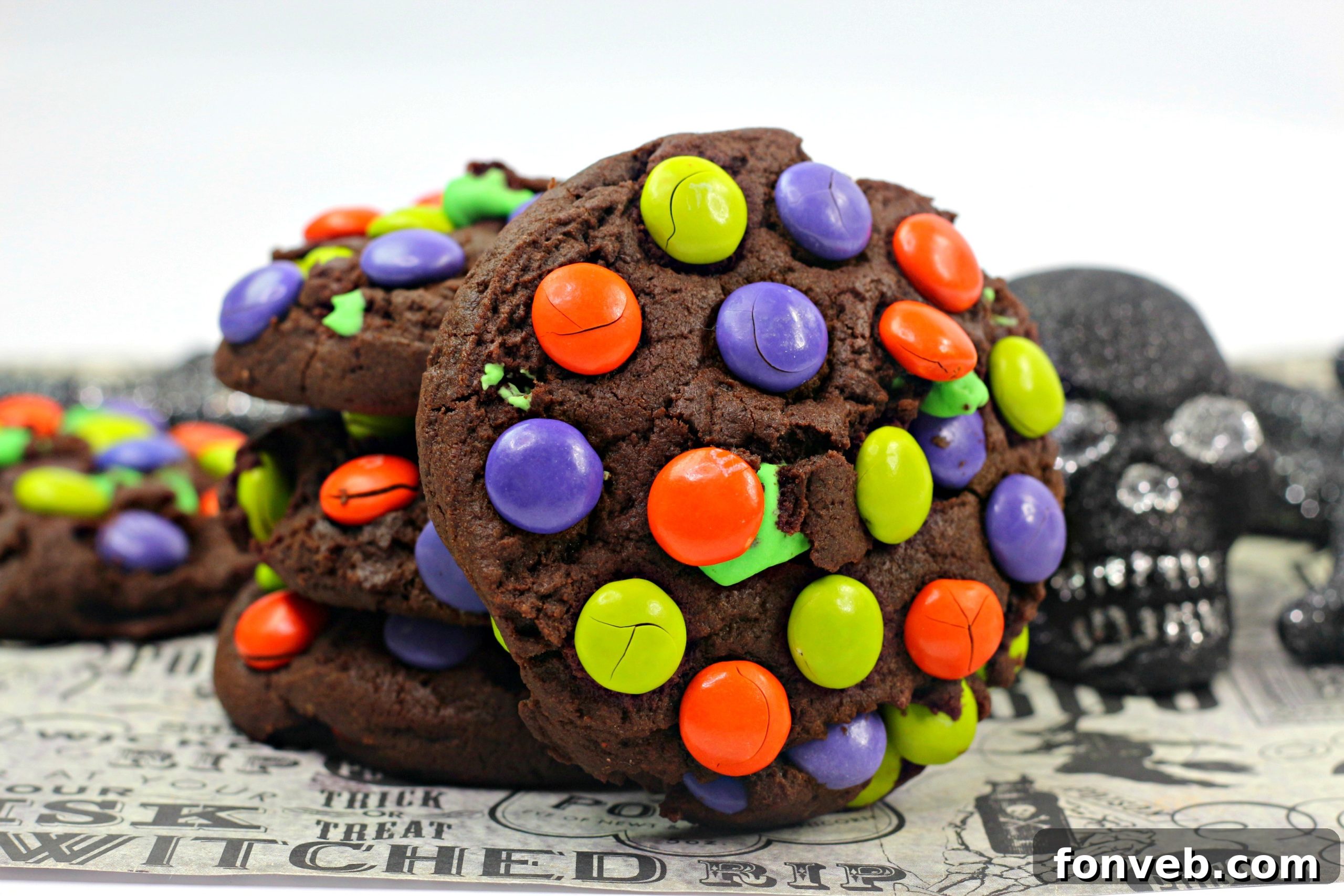 Three Monster Mash Chocolate Cookies arranged artfully, highlighting the varying colors of M&Ms on top.