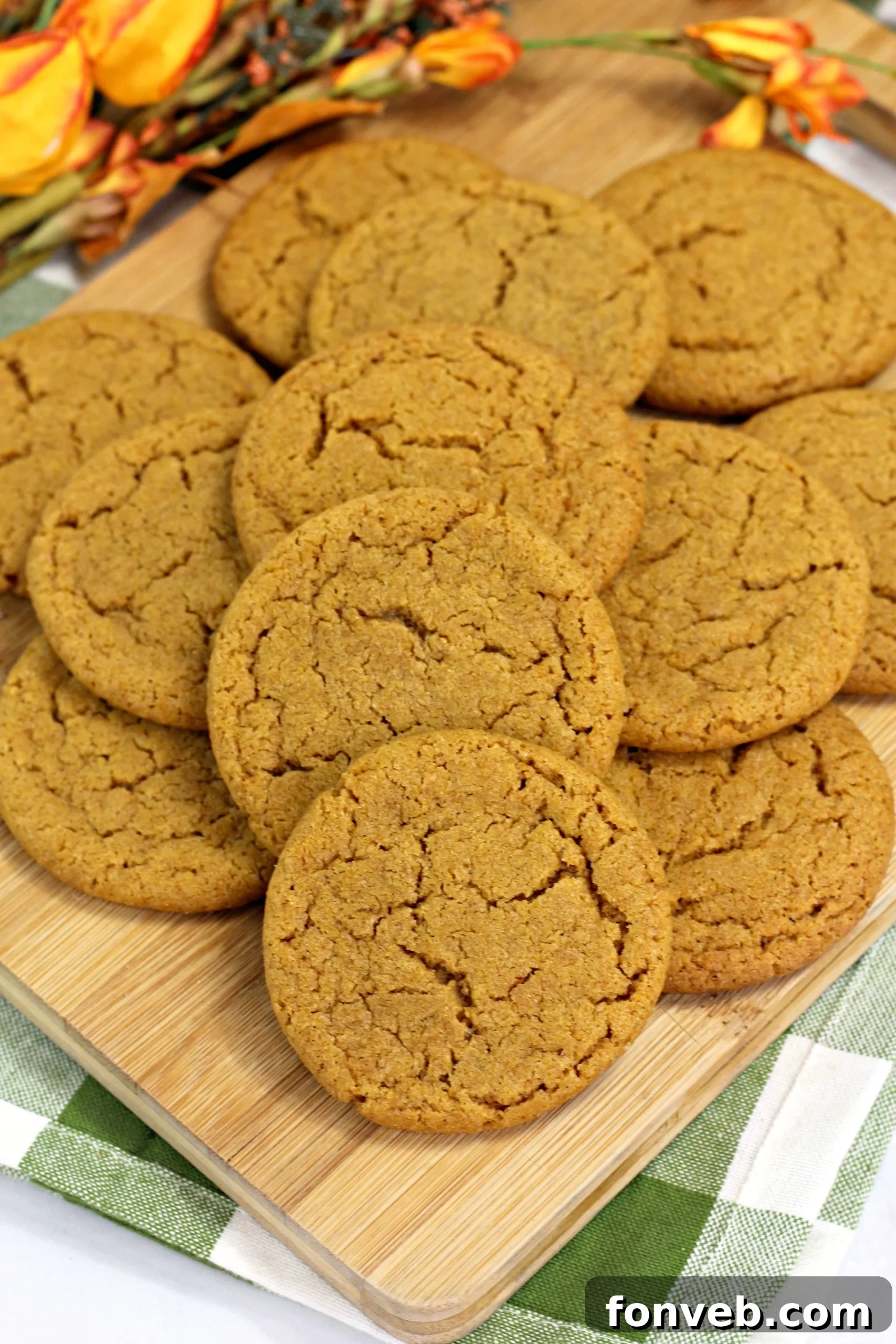 Close-up of a stack of Chewy Pumpkin Gingersnap Cookies with a dusting of sugar